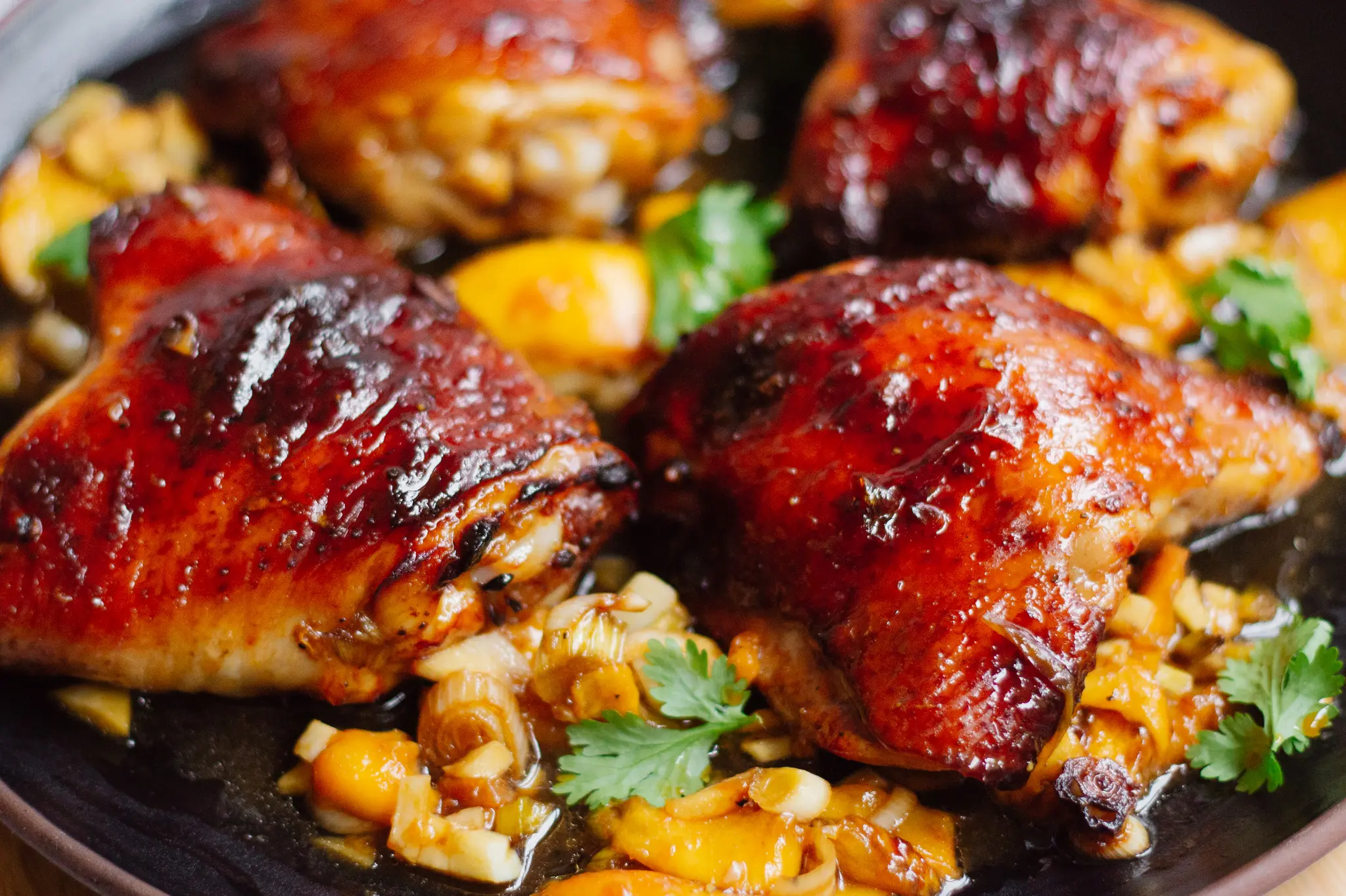 Crispy peach chicken thighs cooked, plated, and garnished
